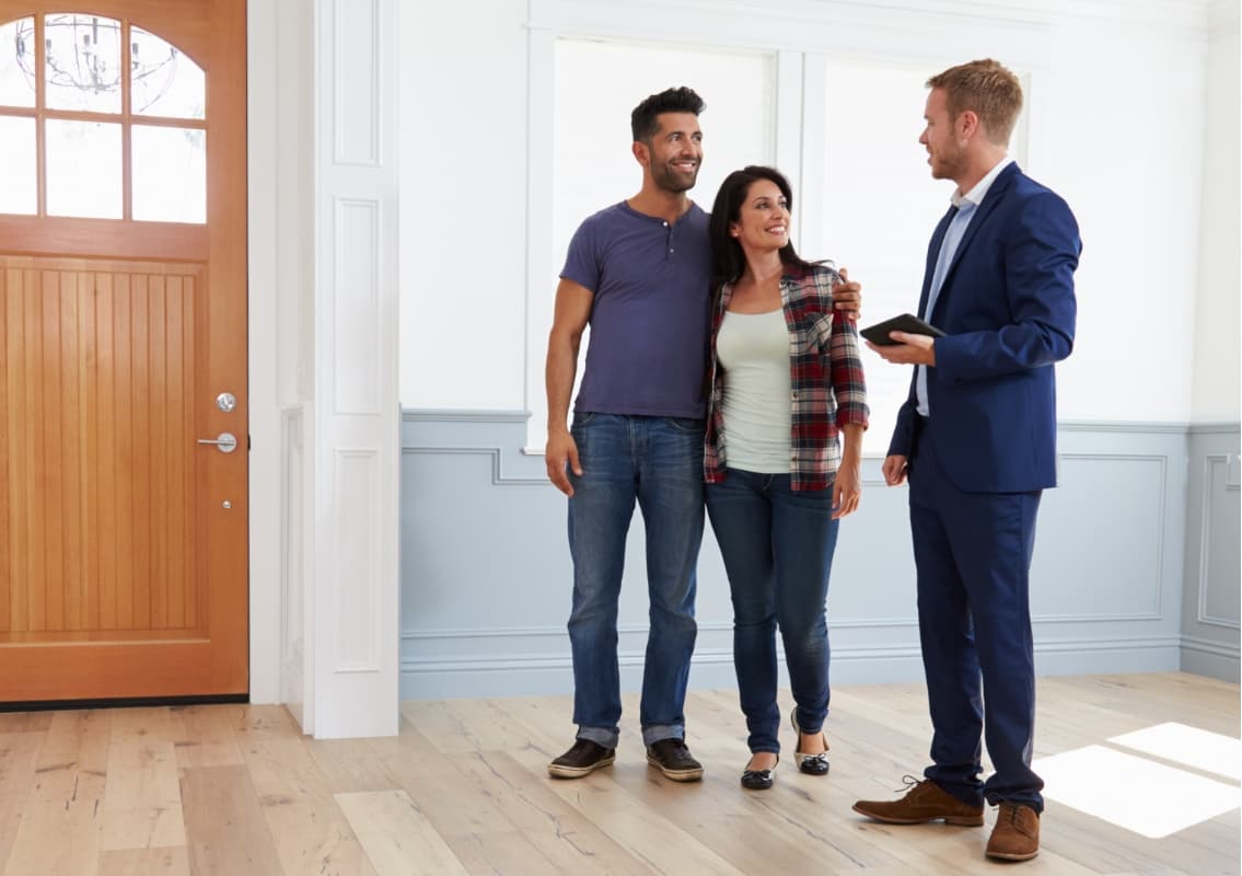 Couple talking to realtor in new home